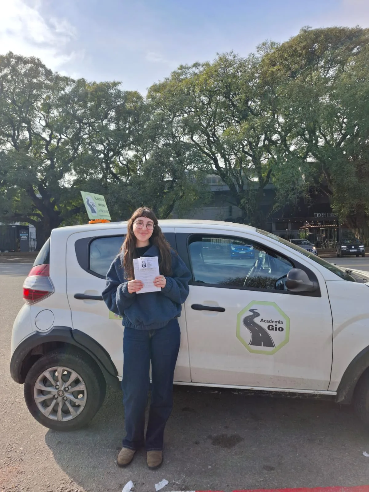 Alumna aprobada frente al coche de Academia Gio